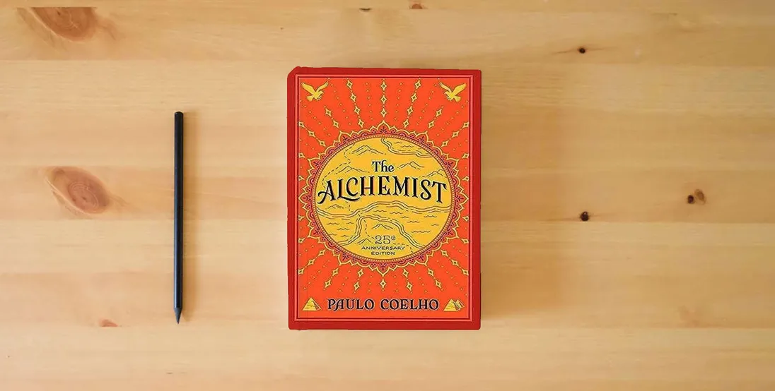 The book The Alchemist, 25th Anniversary: A Fable About Following Your Dream} is on the table