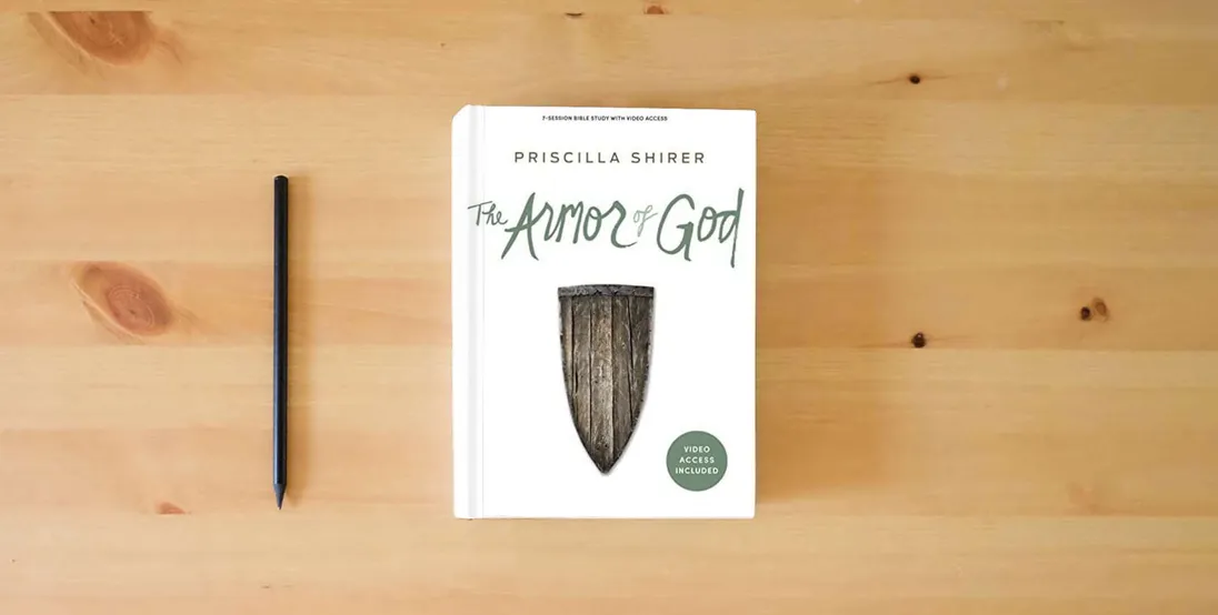 The book The Armor of God - Bible Study Book with Video Access} is on the table