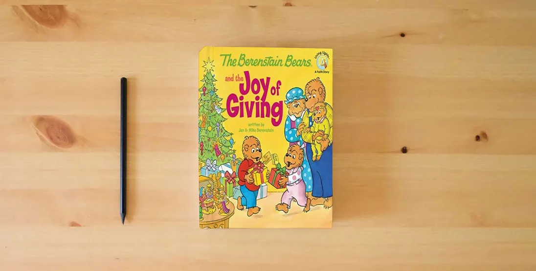 The book The Berenstain Bears and the Joy of Giving: The True Meaning of Christmas} is on the table