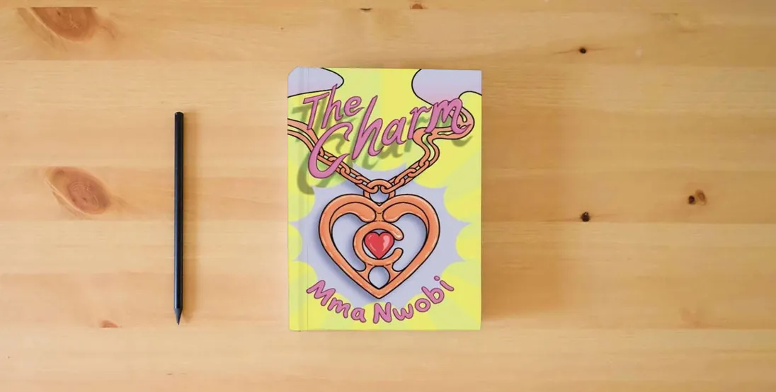 The book The Charm (No. 1): A Children's Book About Courage (The Charm series)} is on the table