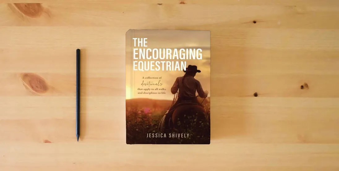 The book The Encouraging Equestrian: A Collection of Devotionals That Apply to All Walks and Disciplines in Life} is on the table