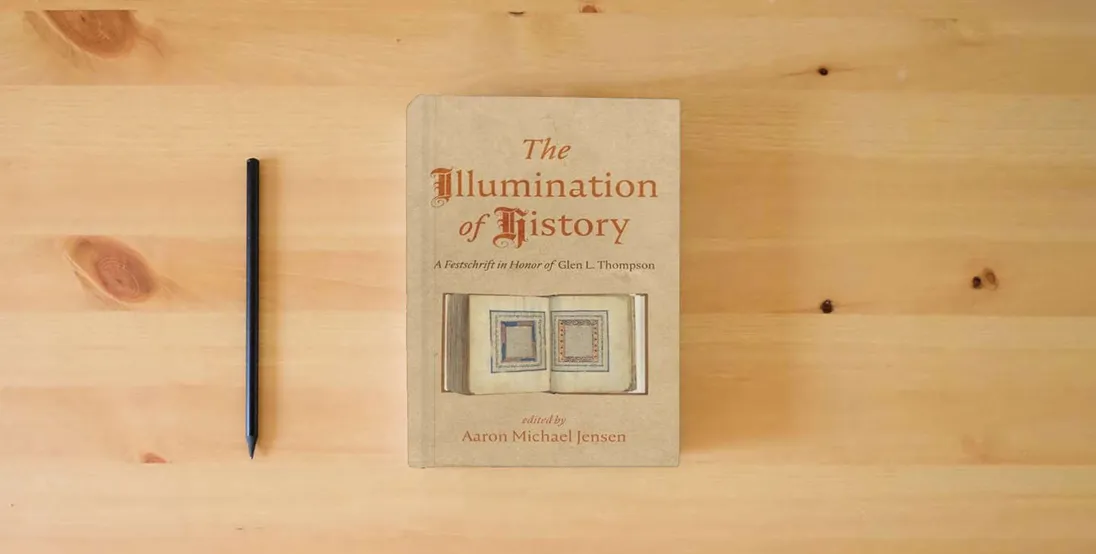 The book The Illumination of History: A Festschrift in Honor of Glen L. Thompson} is on the table
