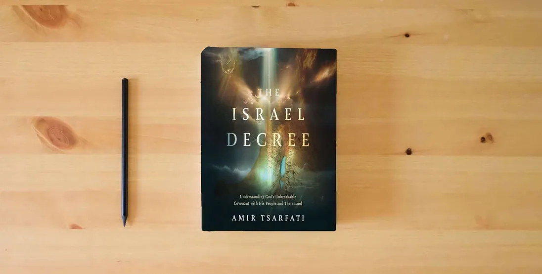 The book The Israel Decree: The Past, Present, and Future of the World's Most Controversial Strip of Land} is on the table