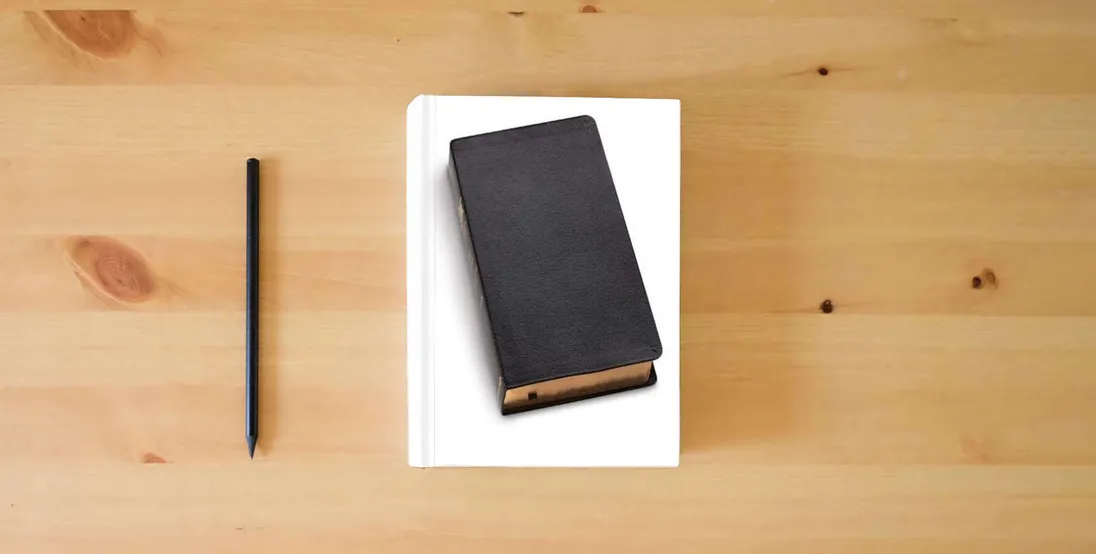 The book The Message Black Genuine Leather: The Bible in Contemporary Language} is on the table