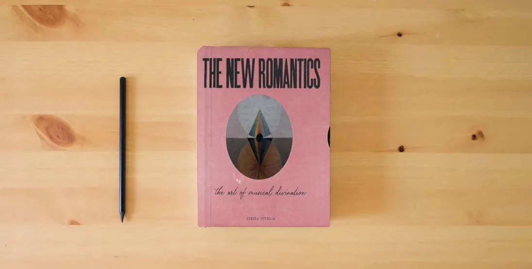 The book The New Romantics: The Art Of Musical Divination} is on the table