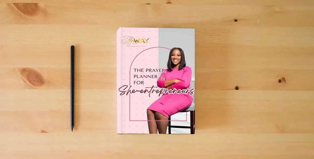 The book The Prayer Planner for She-Entrepreneurs: Manifesting Dreams Through Faith and Action} is on the table