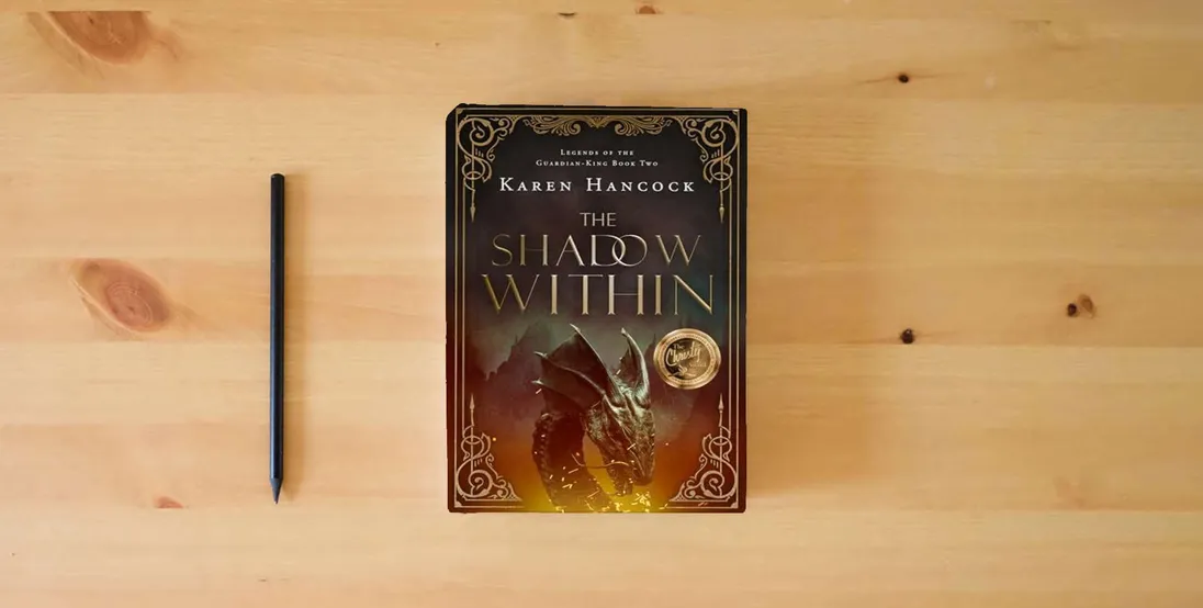 The book The Shadow Within (Volume 2) (Legends of the Guardian-King)} is on the table