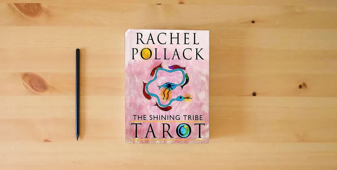The book The Shining Tribe Tarot (The Definitive Edition): 83 Cards and 272-Page Full-Color Guidebook} is on the table