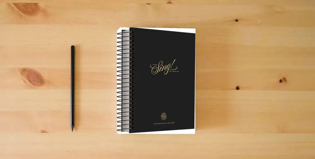 The book The Sing! Hymnal, Accompanist Edition} is on the table