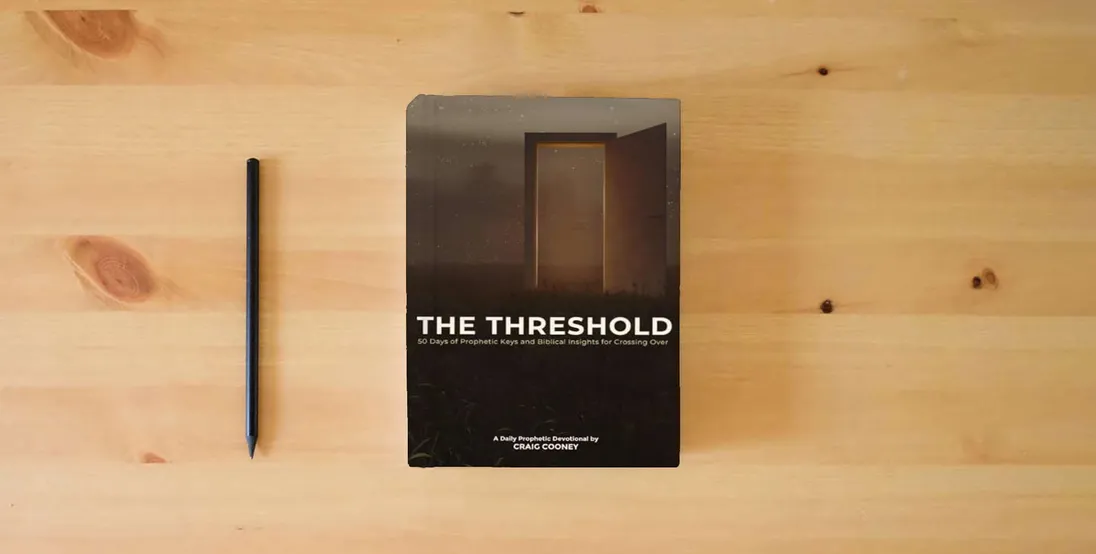 The book THE THRESHOLD: 50 Days of Prophetic Keys and Biblical Insights for Crossing Over} is on the table