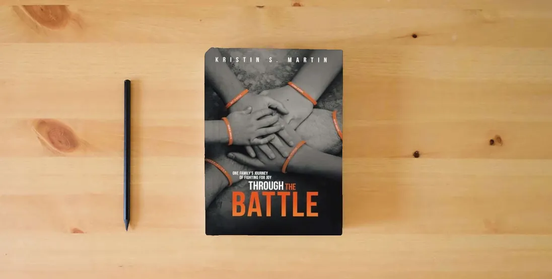 The book Through the Battle: One Family's Journey of Fighting for Joy} is on the table