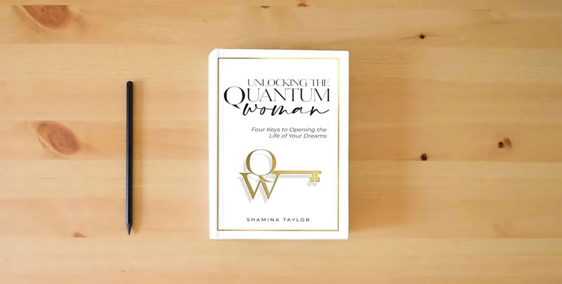 The book Unlocking The Quantum Woman: Four Keys to Opening the Life of your Dreams} is on the table