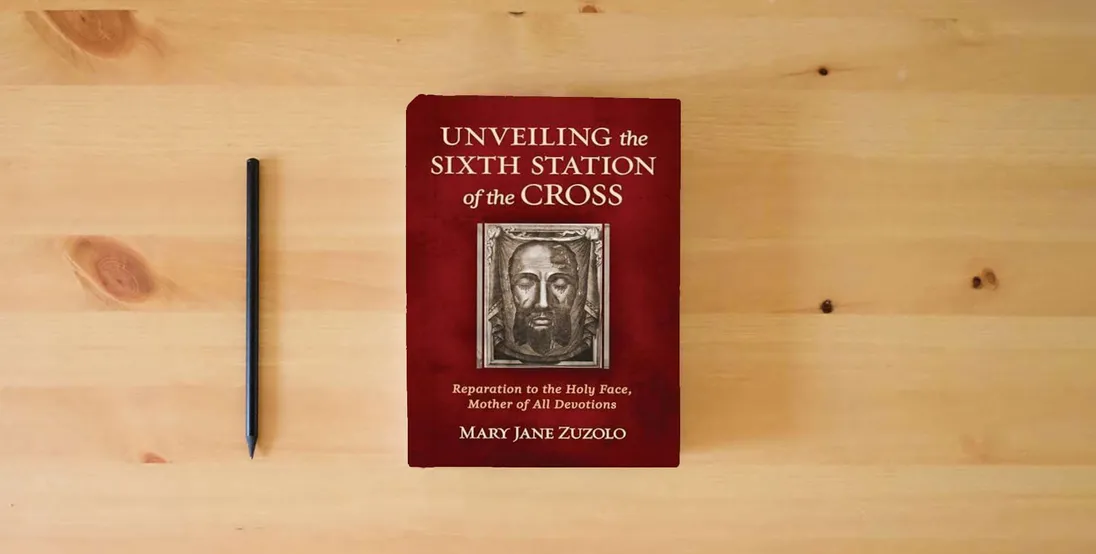 The book Unveiling the Sixth Station of the Cross: Reparation to the Holy Face, Mother of All Devotions} is on the table