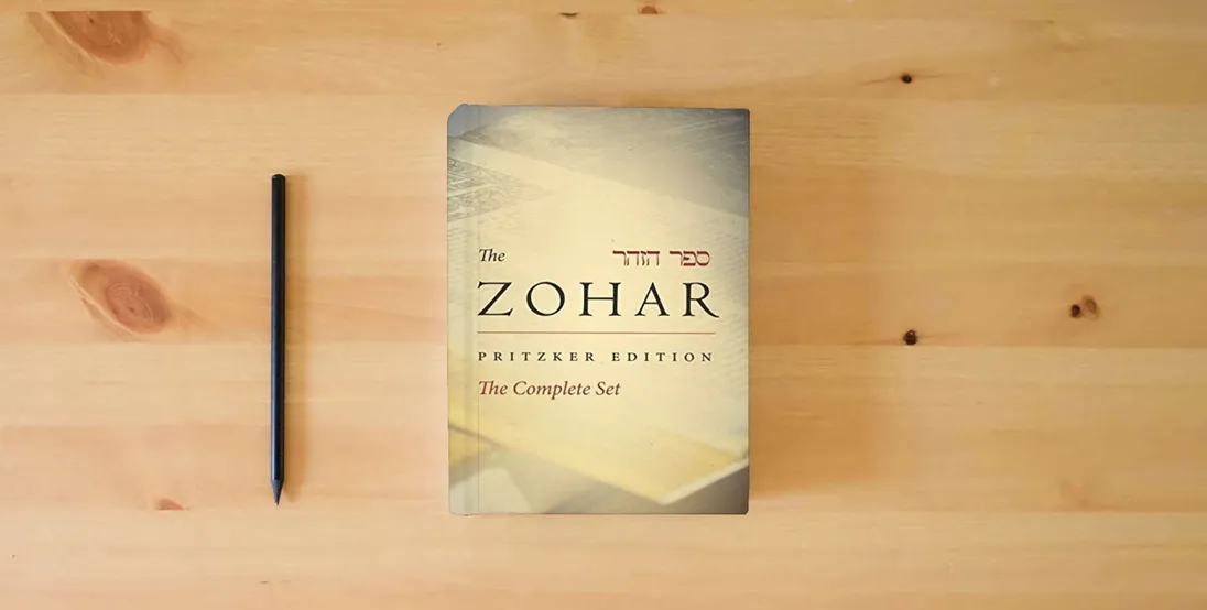 The book Zohar Complete Set (Zohar: The Pritzker Editions)} is on the table